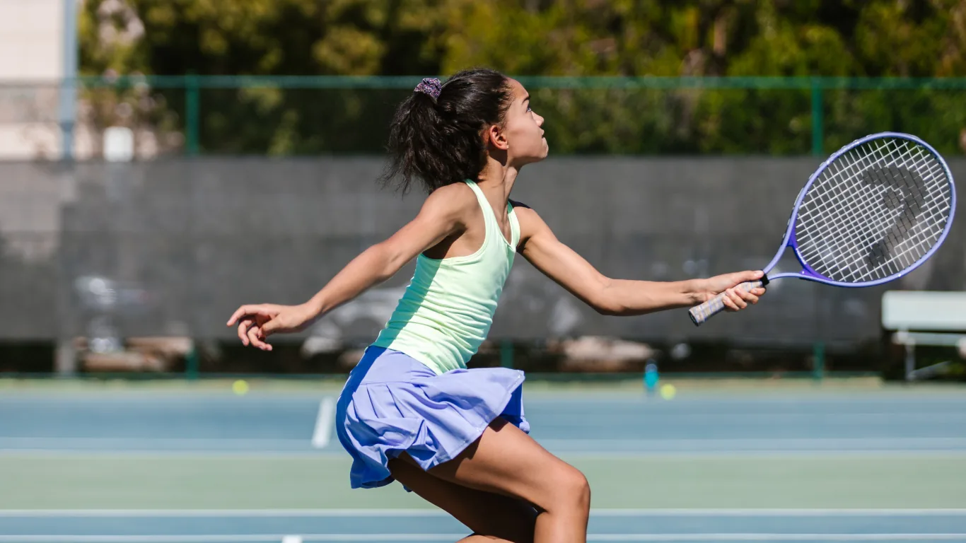 Kids playing tennis mid-skill